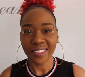 "Trigger The Tingles" with red hair smiling.