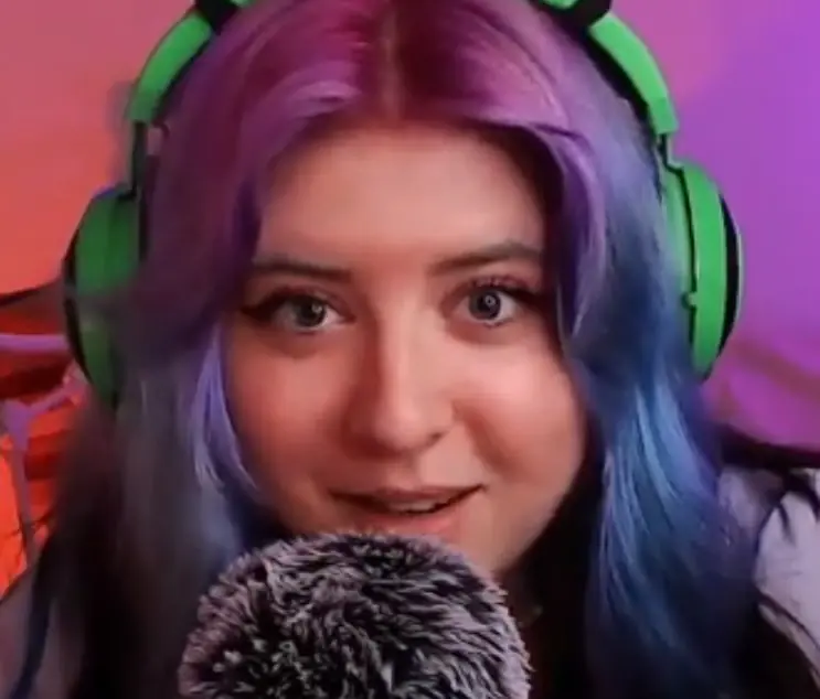 "Doris ASMR" with green headphones and purple hair.