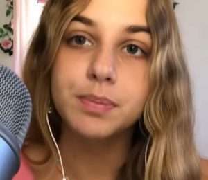 "ASMR Spring" in a cute pink outfit with a microphone