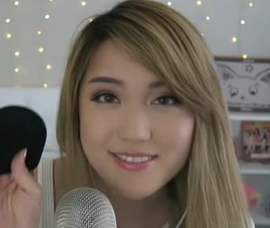 "ANGELS ASMR" holding a sock to put on her ASMR microphone.