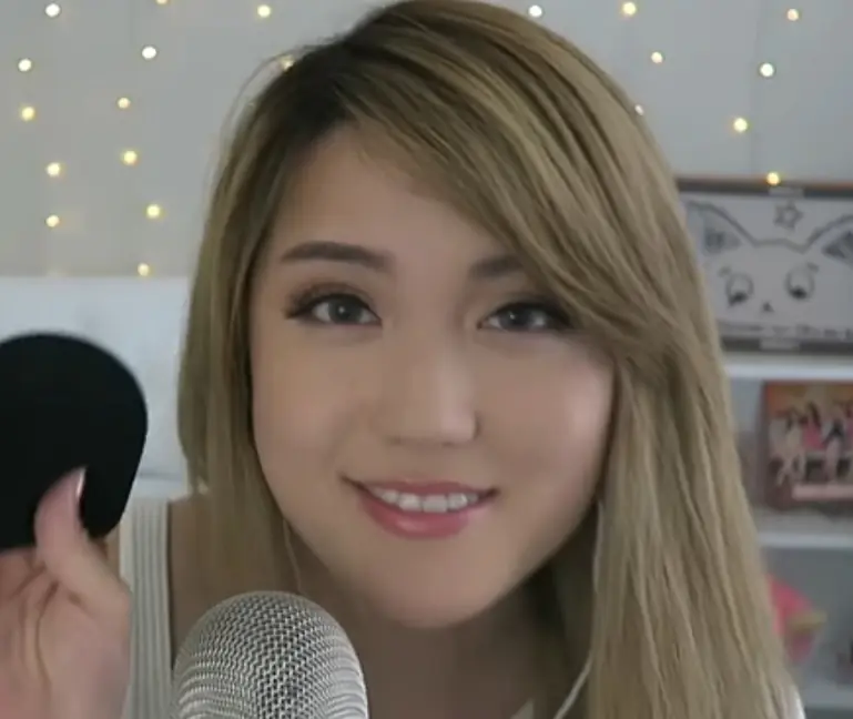 "ANGELS ASMR" holding a sock to put on her ASMR microphone.
