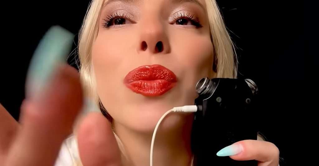 Pelin ASMR, a blonde Turkish ASMR artist with bold red lips and a studio microphone