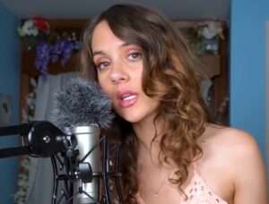 quiet creative wearing glasses and smiling softly during asmr session