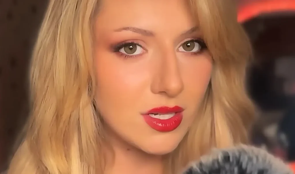 Whispered Worlds, a British ASMR artist, recording a calming session with a soft expression and gentle presence