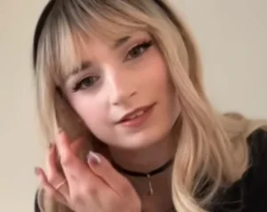 Flora Rodgers with blonde hair as a nurse doing a roleplay.