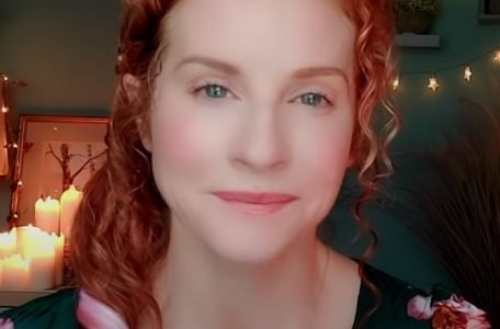 "The ASMR Psychologist" with red hair and a lovely glow.