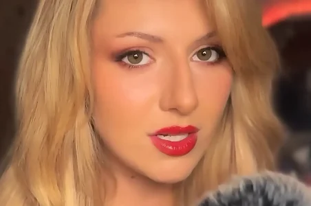 Whispered Worlds, a British ASMR artist, recording a calming session with a soft expression and gentle presence